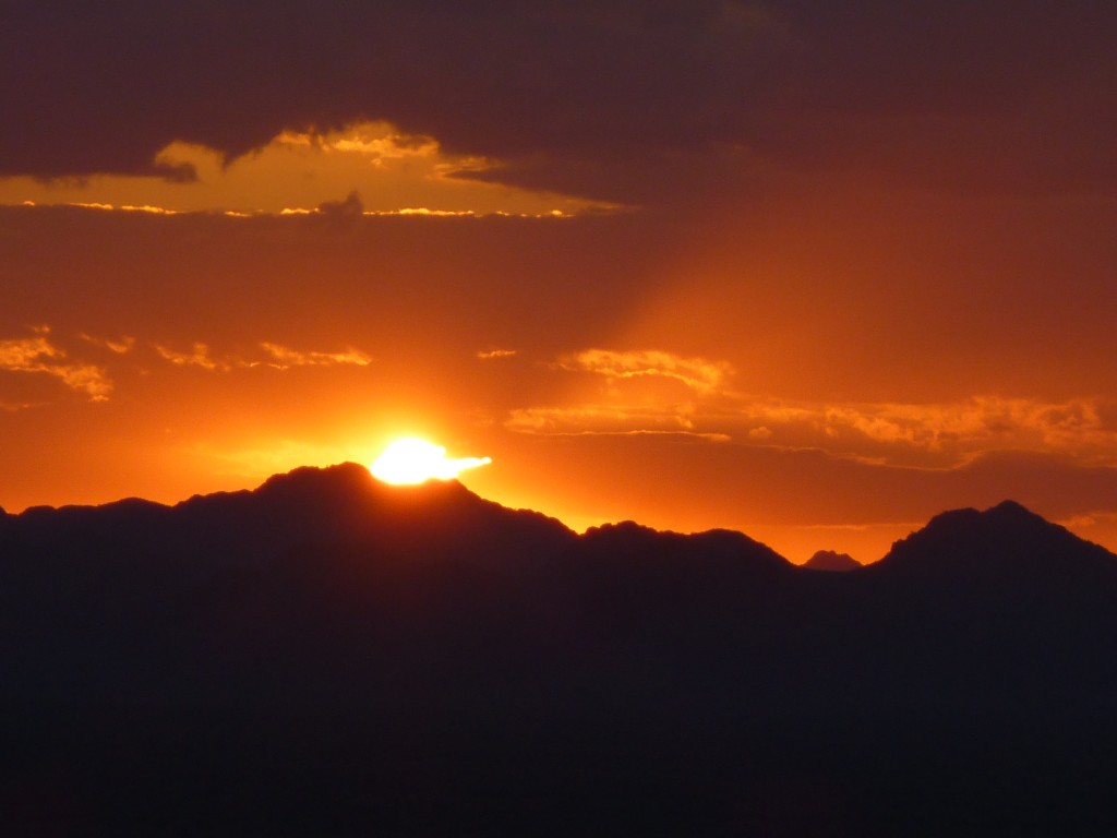 The sun setting behind layers of the Agua Dulce Mountains