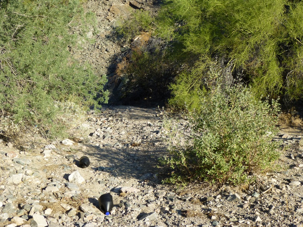 Water jugs and shady overhangs in the wash